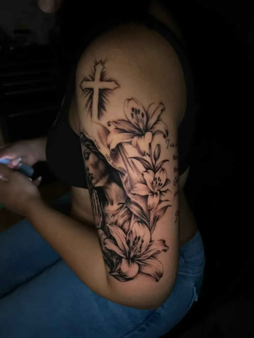 Side view of the Virgin Mary half sleeve with lilies and script